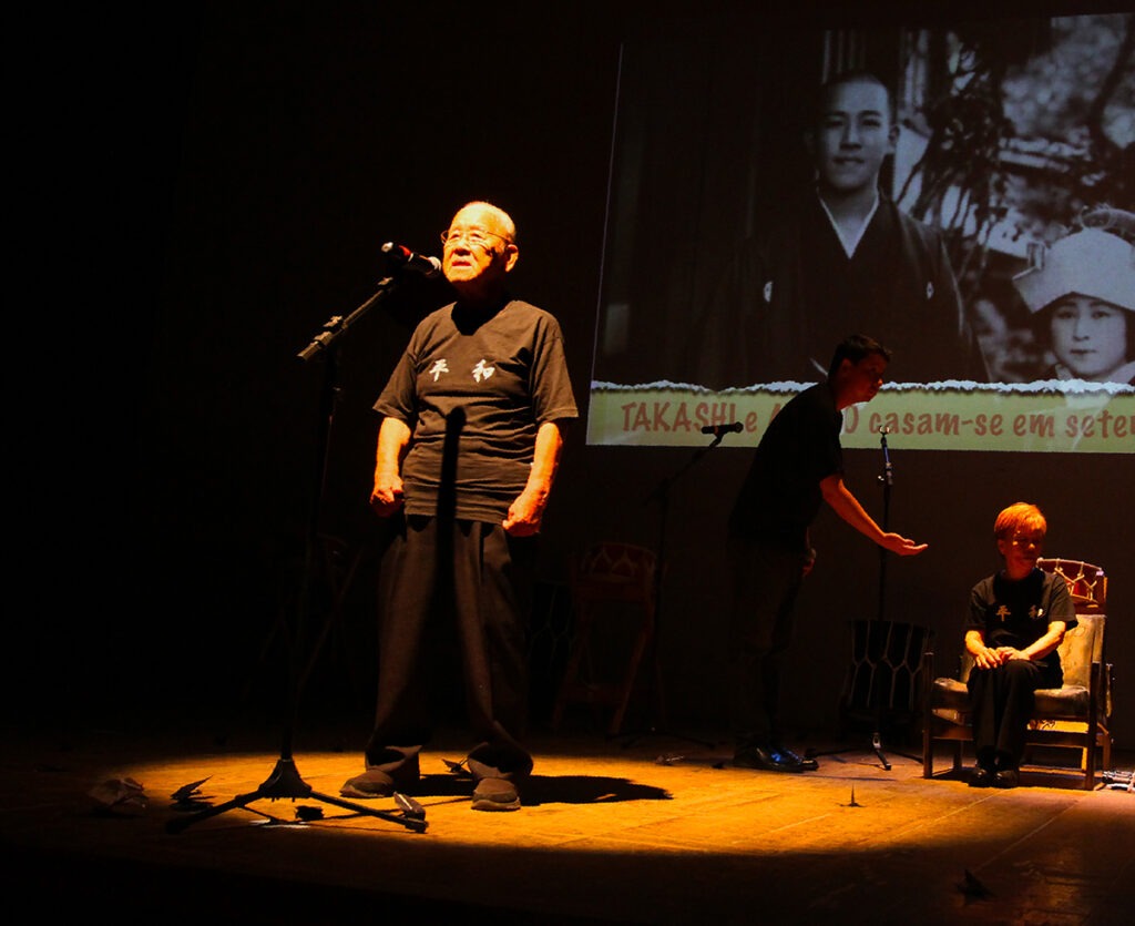 Cena do espetáculo “Os Três Sobreviventes de Hiroshima” com Kunihiko Bonkohara e Junko Watanabe no palco